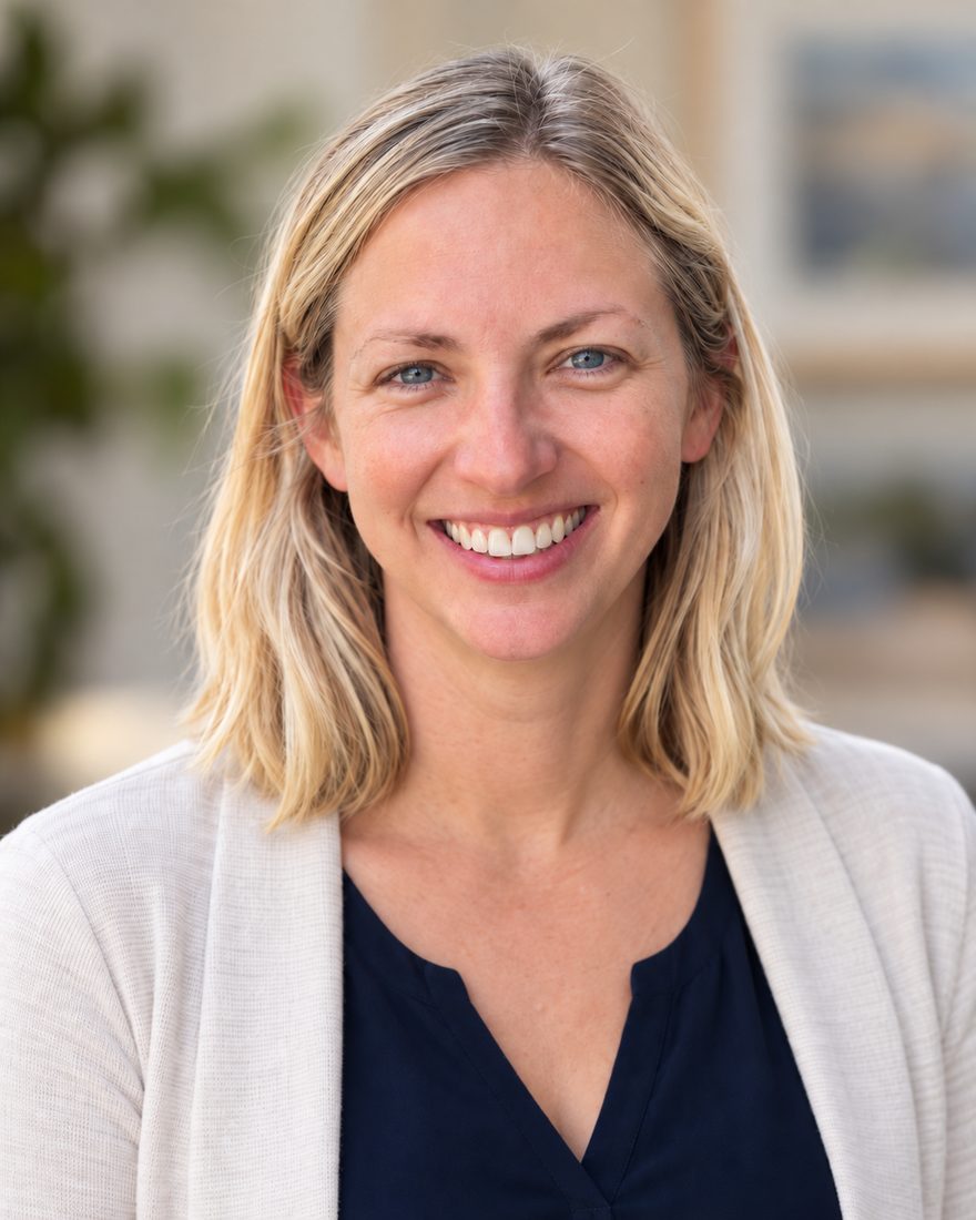 Portrait of Hannah Kautz, smiling, wearing a cream cardigan